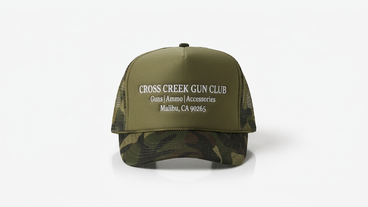 Green and camouflage cap with 'Cross Creek Gun Club' text on a white background